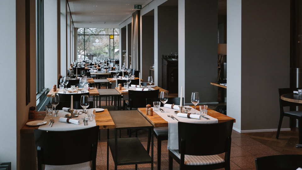 Tables près d'une longue baie vitrée avec vue sur Berne au restaurant Gurtners