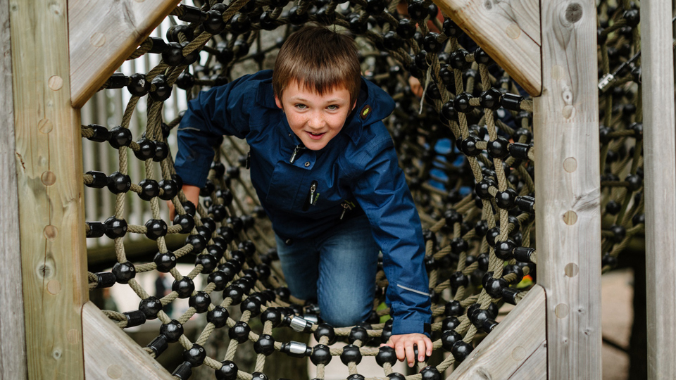 A child climbing through the climbing frame