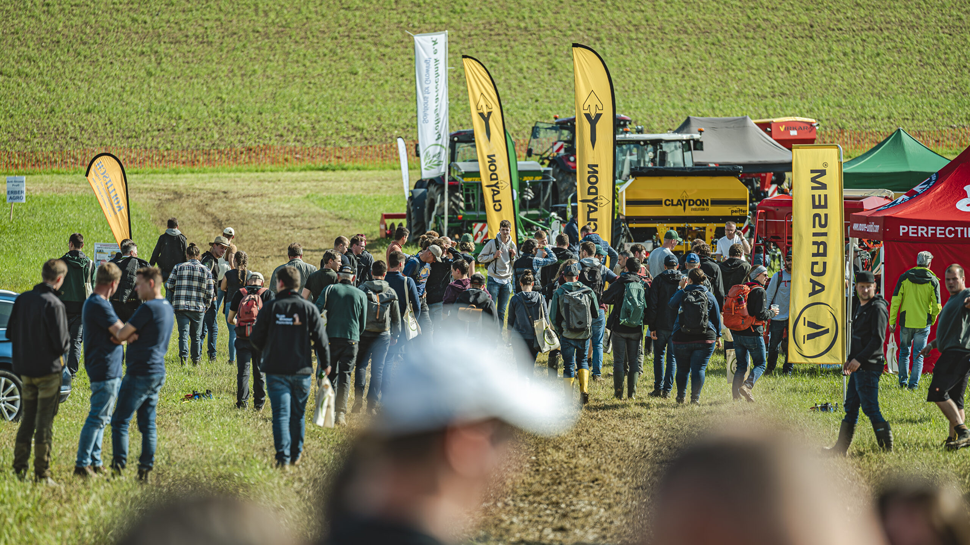 Beaucoup de monde et de machines agricoles sur la grande prairie du site de la fête