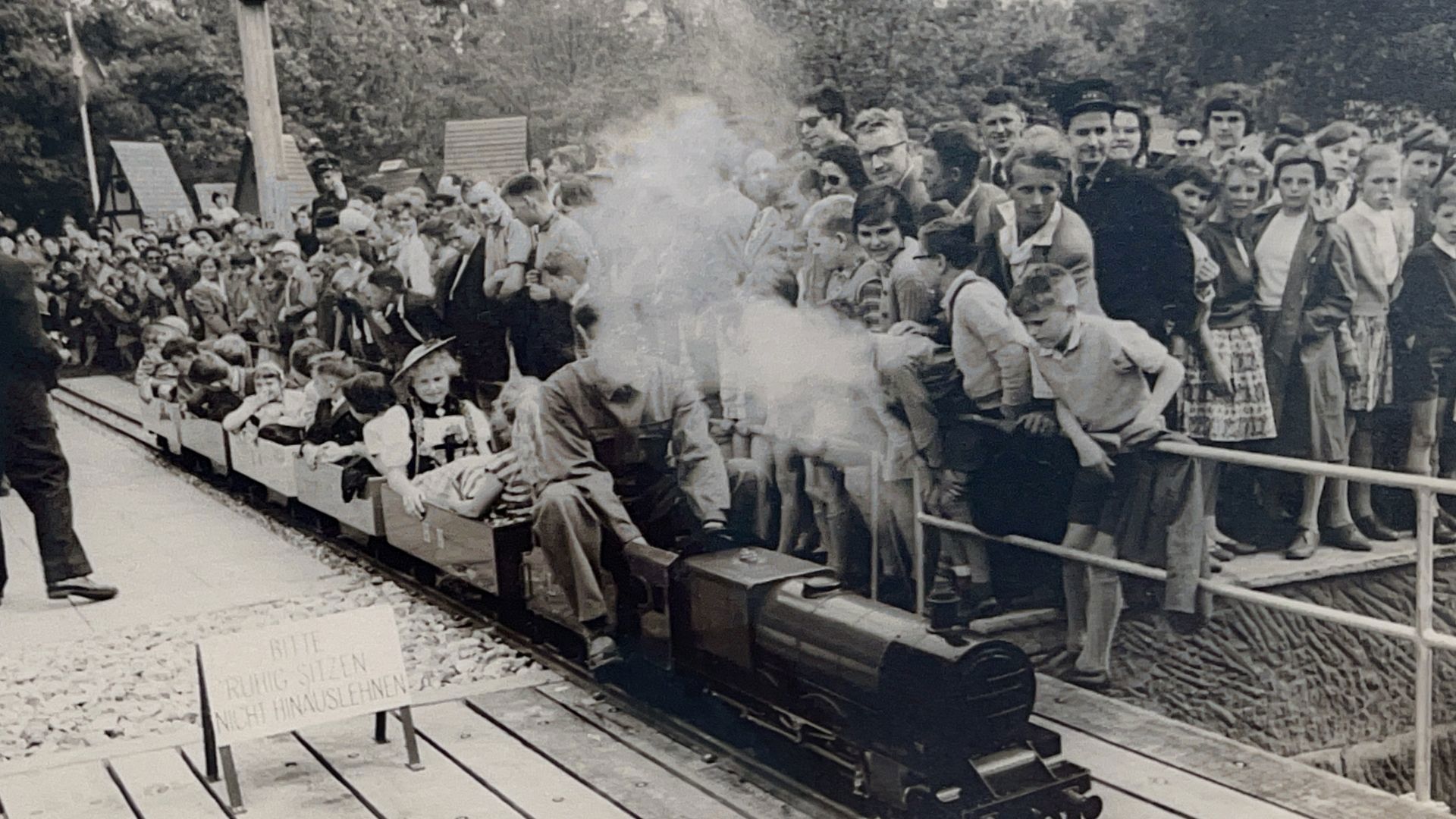Small railway on its first journey with curious onlookers.