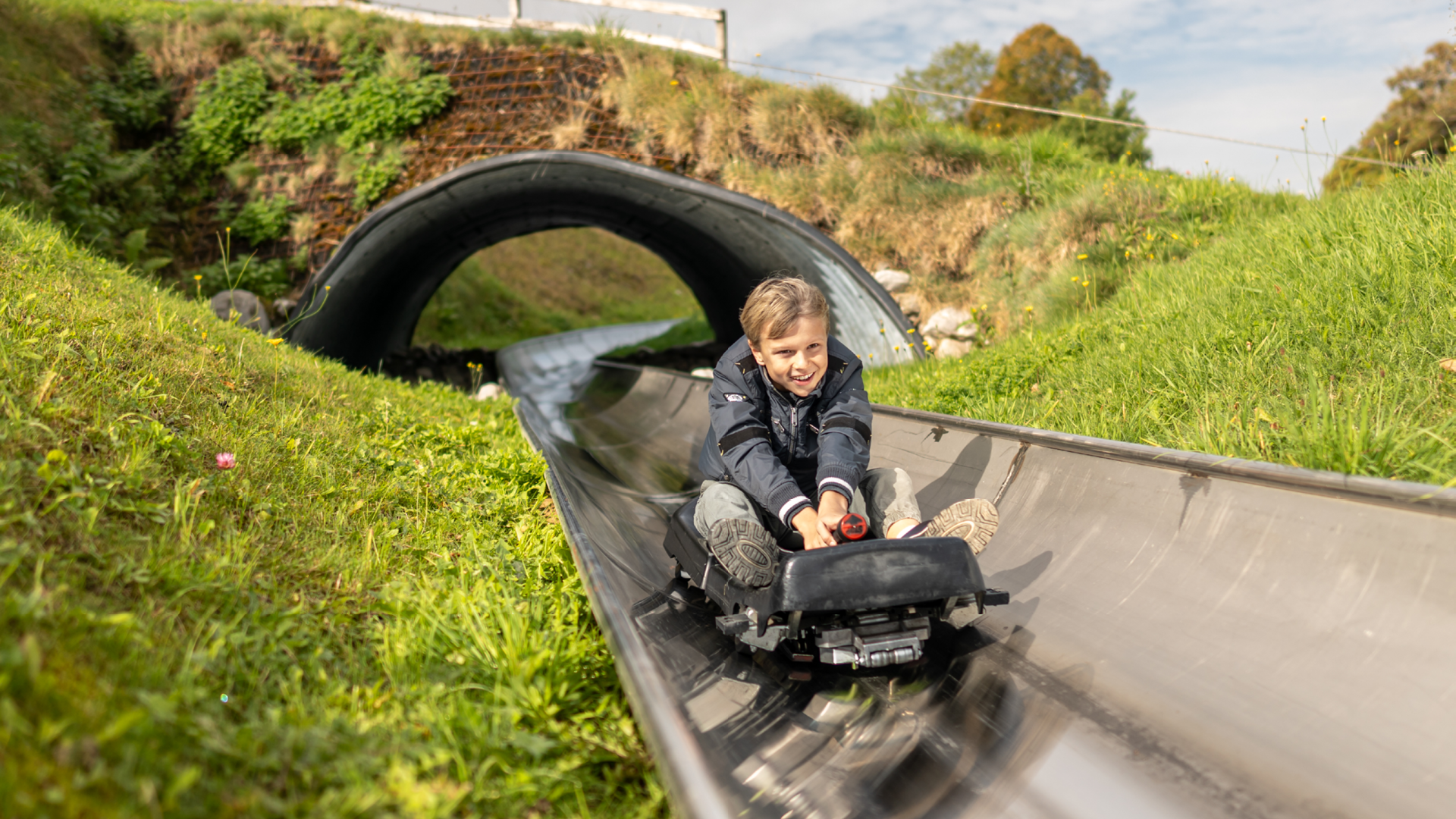 Boy comes out of the toboggan run tunnel