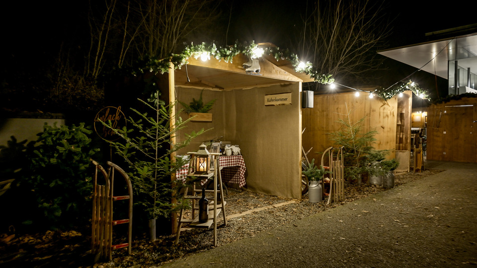 Village d’hiver sur le Gurten avec des chalets en bois illuminés de nuit.