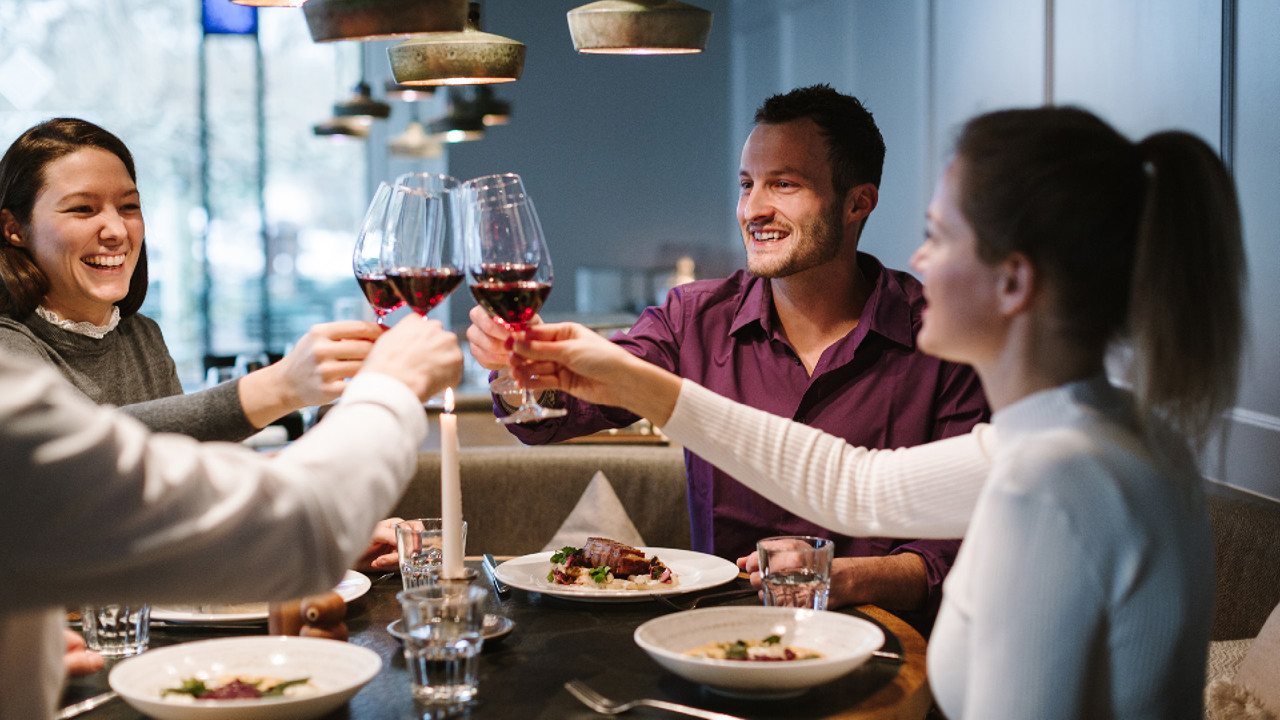 Four people enjoying a glass of red wine at Restaurant Gurtners on Geniessermontag.