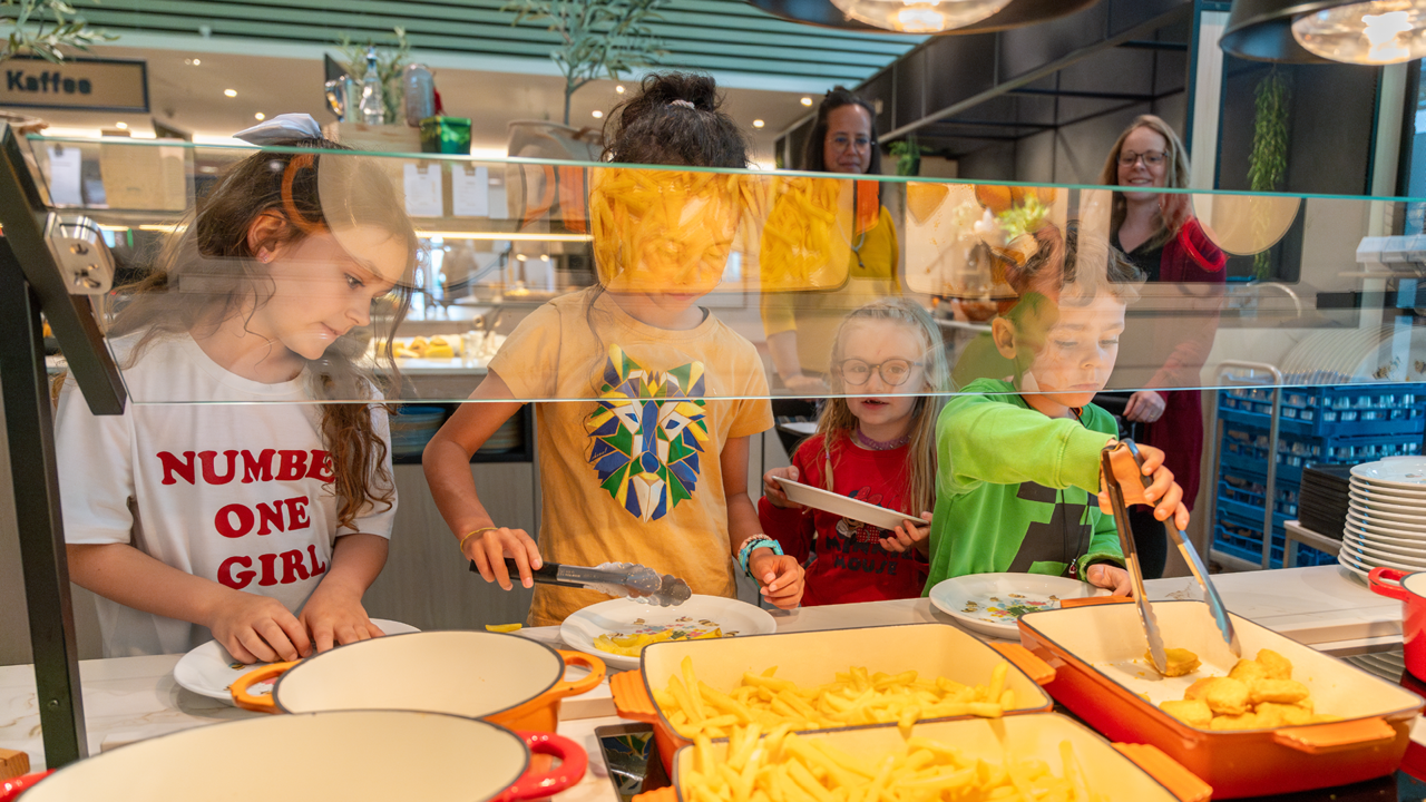 Four children serving themselves at the children's buffet in the Huusbüffe restaurant.