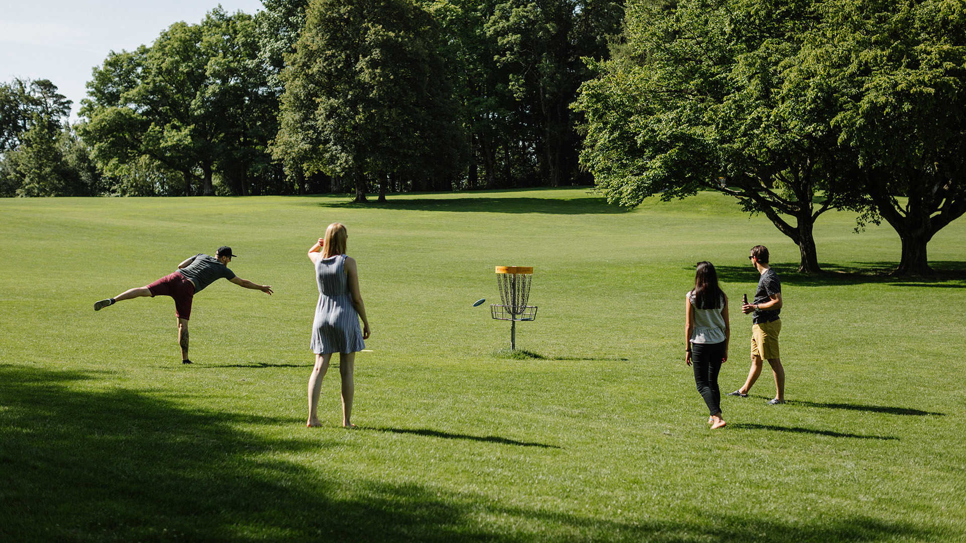 Four people playing disc golf on a green field on Gurten