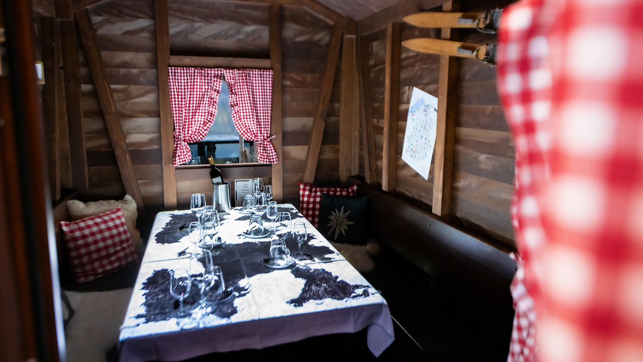 Ein kleines Holzchalet von innen mit Beleuchtung.