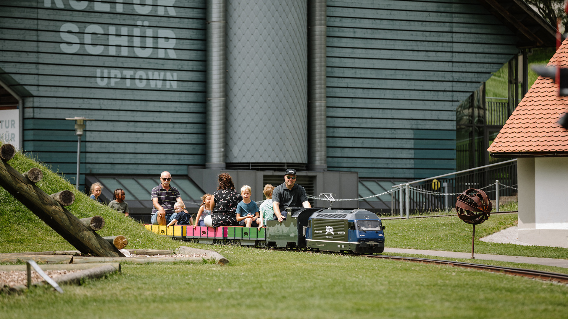 Small train runs through playground with many passengers