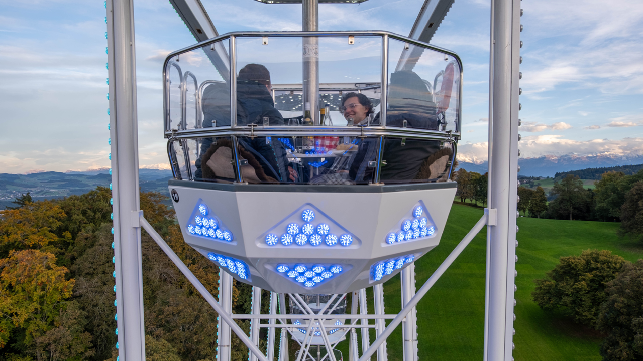 Mehrere Personen welche im Riesenrad sitzen.