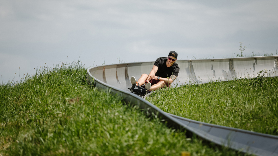 Un homme descend la piste de luge.