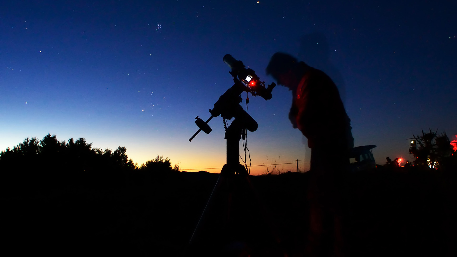 Une personne qui observe le ciel à l'aide d'un télescope.