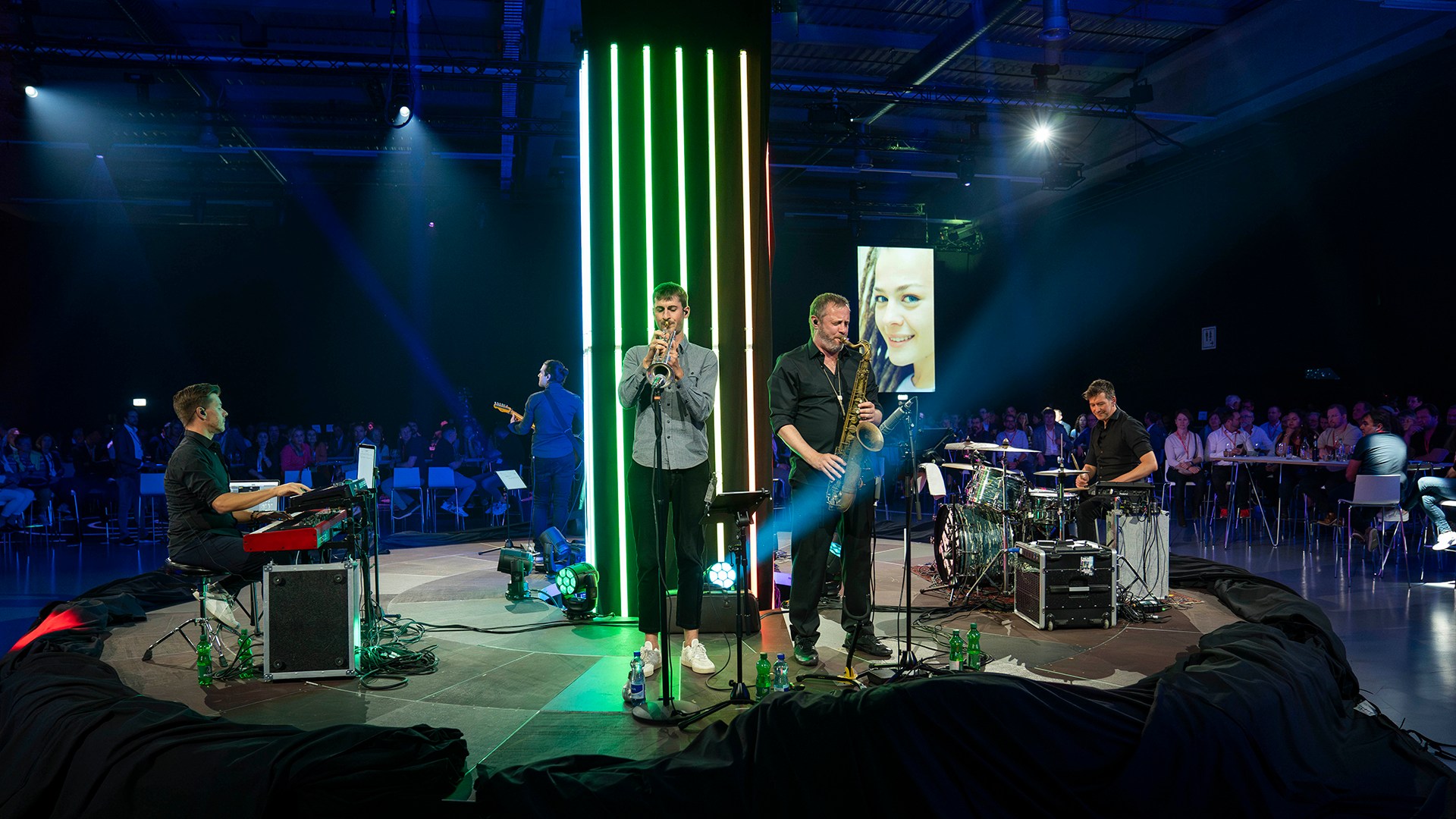 Un groupe sur une scène ronde au milieu des spectateurs