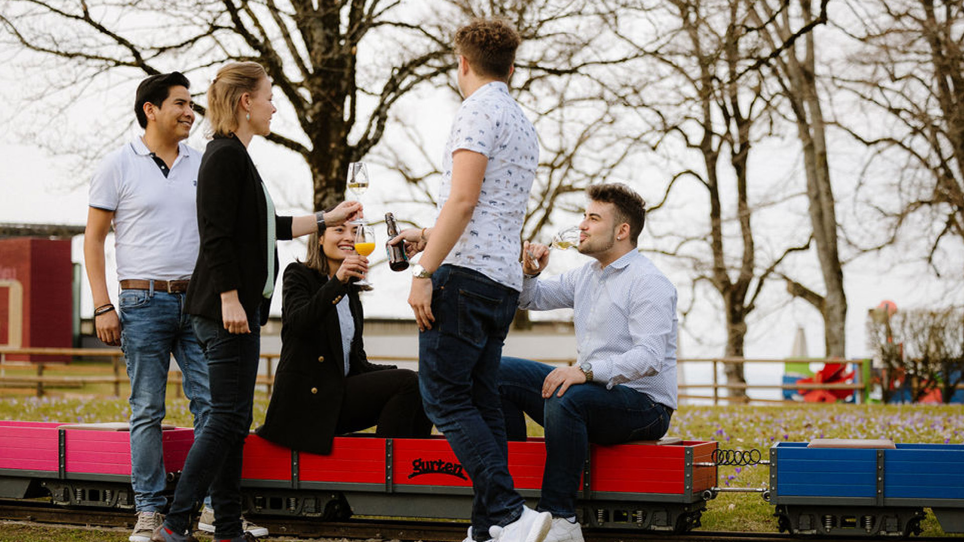 Cinq personnes à bord d'un petit train lors d'un apéritif