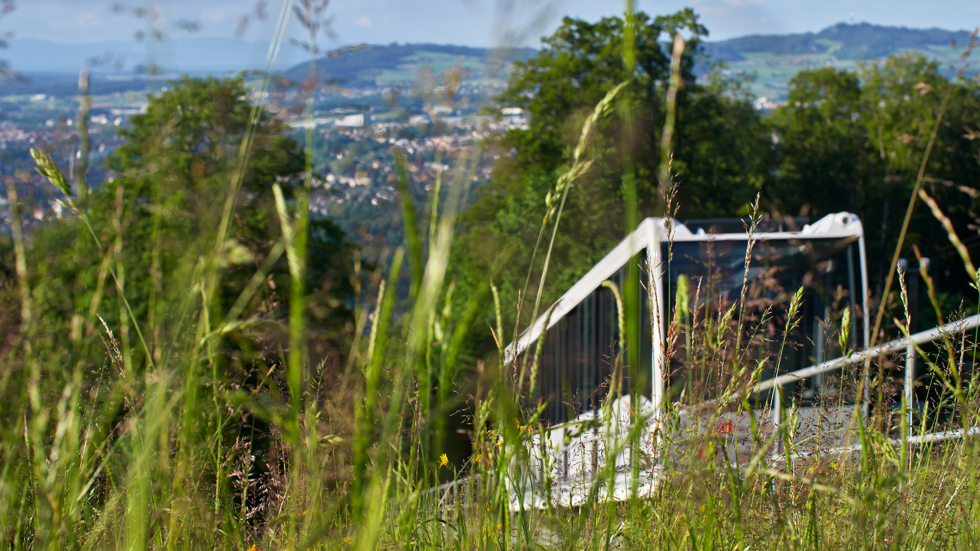 A shot taken from tall grass of the Gurtenbahn railway and the town of Köniz.